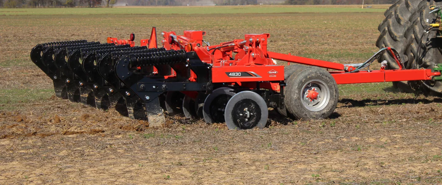 A side view of a KUHN Krause 4830 trailed in-line ripper working the ground.