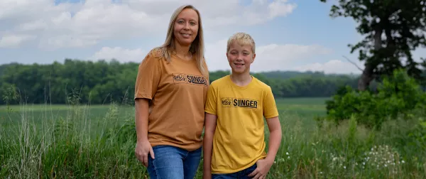 Woman and child wearing KUHN retro Slingser t-shirts